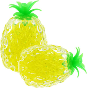 Two yellow pineapple-shaped stress toys with green tops on a white background