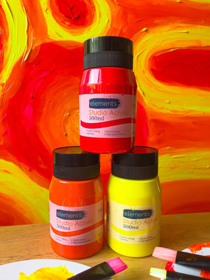 Acrylic paint tubs stacked together in a triangle which a yellow and red painted background