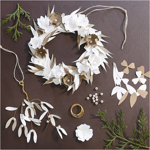 Decorative wreath with white flowers and green leaves on a brown background