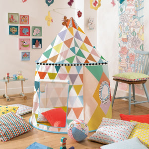 Colorful geometric play tent in a child's room with toys and pillows.