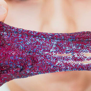Close-up of a glittery red and blue top worn by a person.