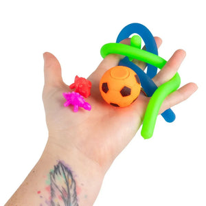 Hand holding colorful sensory toys against a white background