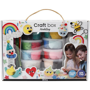 Craft box with modeling materials including foam clay and silk clay, featuring children playing with the contents.