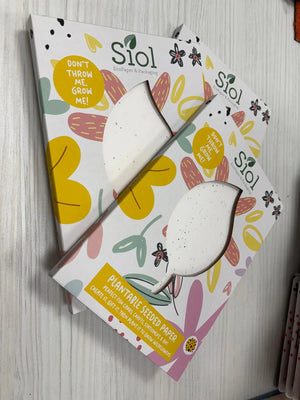 Two Siol plantable seed paper packages on a wooden surface