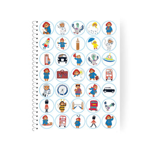 Notebook with circular stickers featuring cartoon characters and icons on a white background