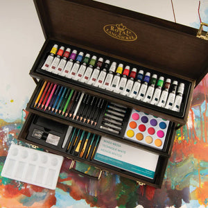 Art supply set with paint tubes, brushes, and other tools in a wooden box on a colorful painting background.