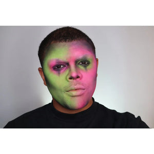 Person with Snazaroo green and pink face paint on a plain background
